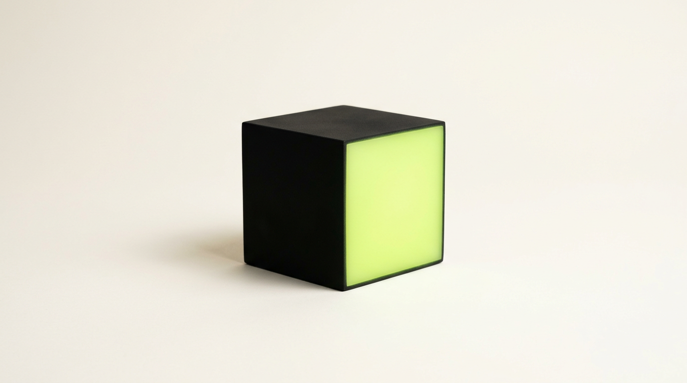 A single matte black cube with one softly glowing lime-lit face on a warm off-white background