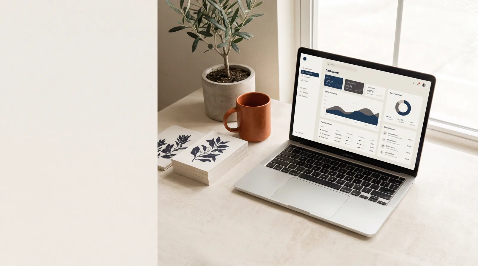 A working desk with a laptop, printed template pages and a mug